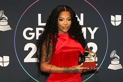 Ludmilla de vestido longo vermelho segurando seu primeiro prêmio no Grammy Latino
