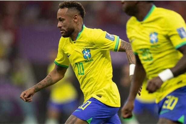 Neymar, com a camisa da Seleção Brasileira, em campo contra a Sérvia, ao lado de outro jogador