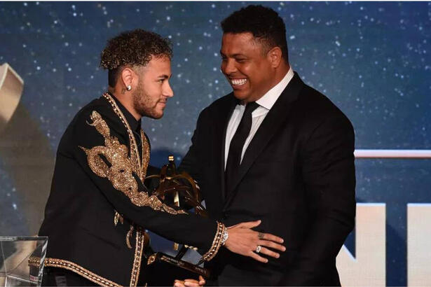 Neymar e Ronaldo juntos em uma premiação. Os dois usam roupas escuras