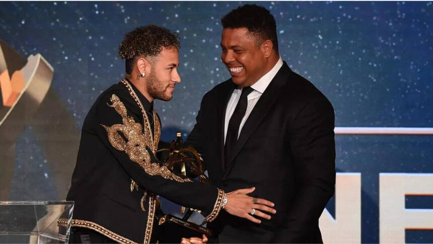 Neymar e Ronaldo juntos em uma premiação. Os dois usam roupas escuras