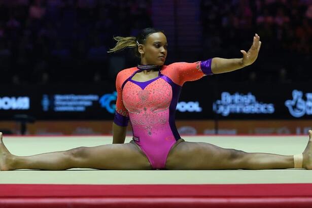 Rebeca Andrade com as pernas abertas no tabloide do Mundial de Liverpool durante apresentação