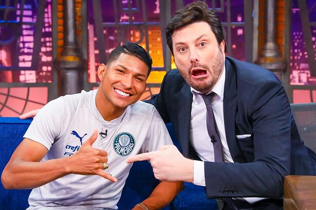 Rony Rústico de camisa branca fazendo hangloose ao lado de Danilo Genitili durante gravação do The Noite, do SBT