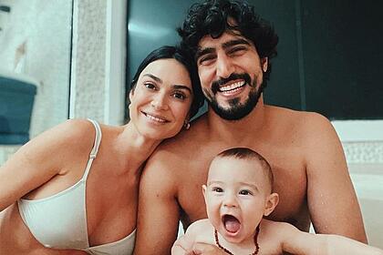 Thaila Ayala de sutiã, sorrindo, ao lado de Renato Góes e seu filho de 11 meses