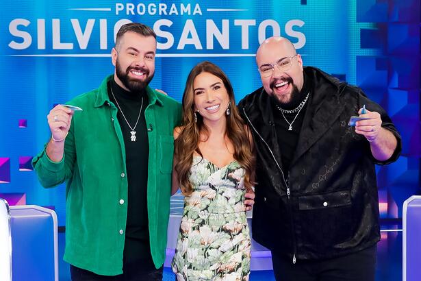 Fernando de jaqueta verde e camisa preta, sorrindo, ao lado esquerdo de Patricia Abravanel; Thiago Abravanel sorrindo ao lado direito de Patrícia durante gravação do Programa Silvio Santos, do SBT