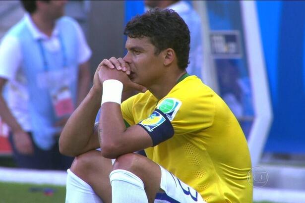 Thiago Silva, com a camisa do Brasil, sentado, chorando, com as mãos apoiadas no queixo