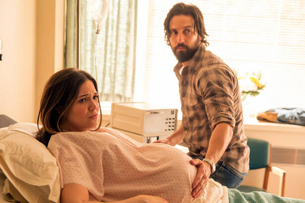 Trecho de um episódio da série This Is Us. Mulher grávida está na cama de um hospital, deitada, com o marido colocando a mão sobre a sua barriga