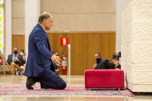 Bispo Edir Macedo de joelhos em um altar da Igreja Universal, em trecho de um culto