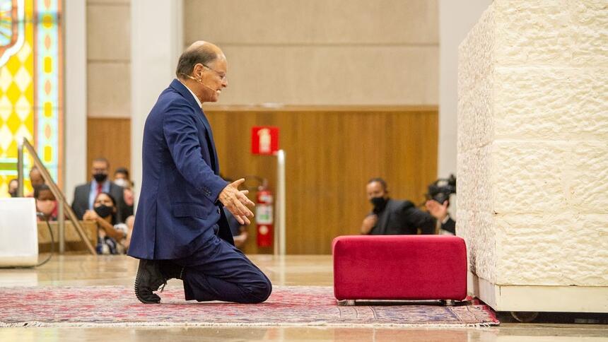 Bispo Edir Macedo de joelhos em um altar da Igreja Universal, em trecho de um culto