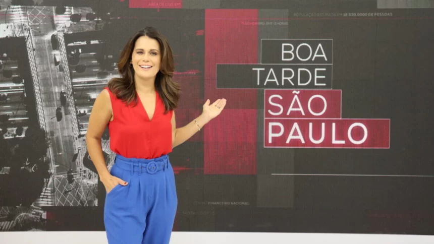 Adriana Araújo apontando para o telão no estúdio do Boa Tarde SP