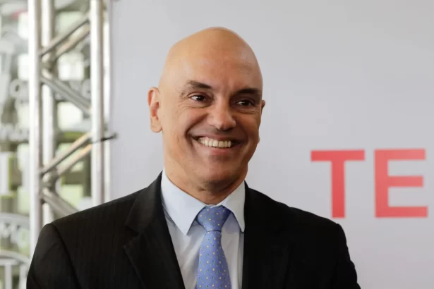 Alexandre de Moraes careca, sorrindo, com paletó preto e gravata preta durante coletiva das eleições