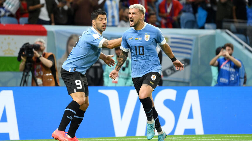 Arrascaeta e Suarez, comemorando gol com a camisa do Uruguai, em jogo pela Copa do Mundo