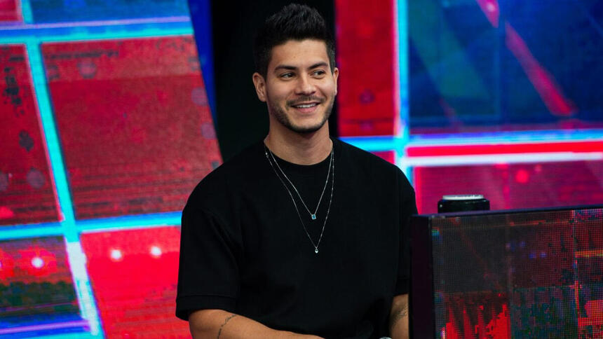 Arthur Aguiar sorrindo de camisa manga longa preta durante gravação do Faustão na Band