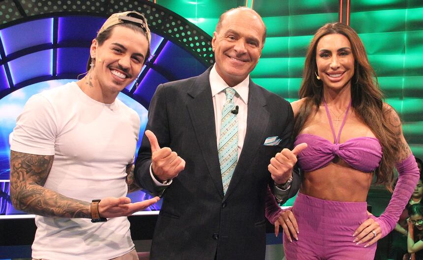 Biel de chapéu bege, camisa branca, sorrindo; Jaque de top e calça lilás, sorrindo, ao lado de Marcelo de Carvalho durante gravação de O Céu é o Limite, da Redetv!