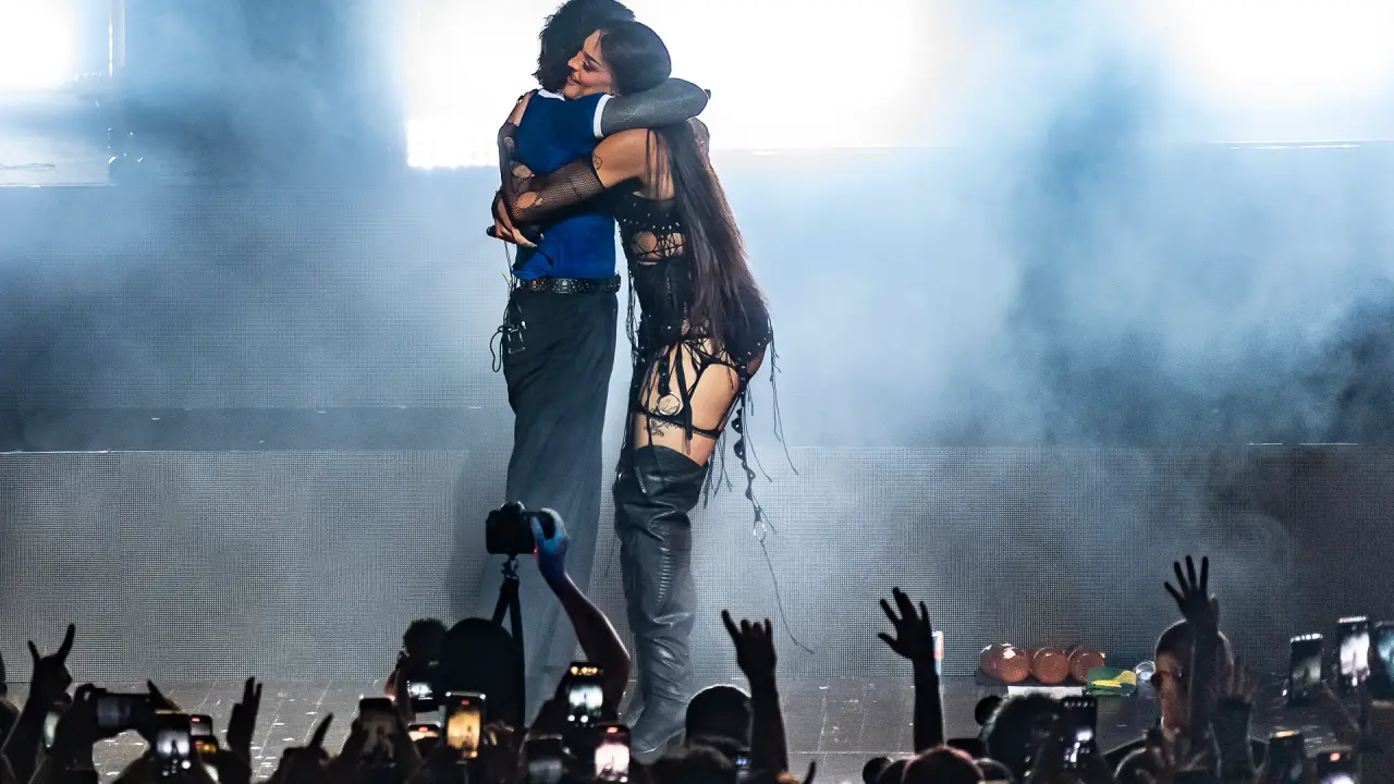 Pabllo Vittar de vestido decotado preto, abraçando o vocalista de Bring Me The Horizon durante participação em show de São Paulo
