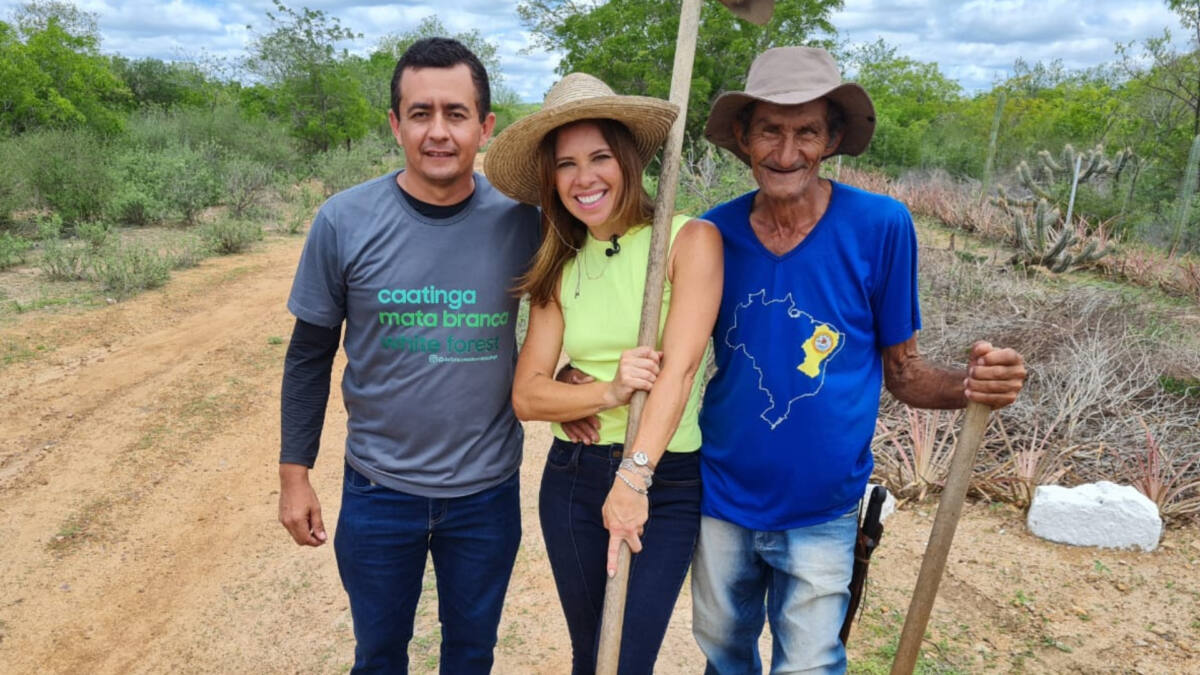Camila Marinho, ao lado de moradores na Uauá, posando com enxadas na caatinga