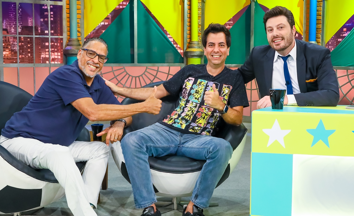 Integrantes do Chupim sentados num banco branco, ao lado de Danilo Gentili durante entrevista no The Noite, do SBT