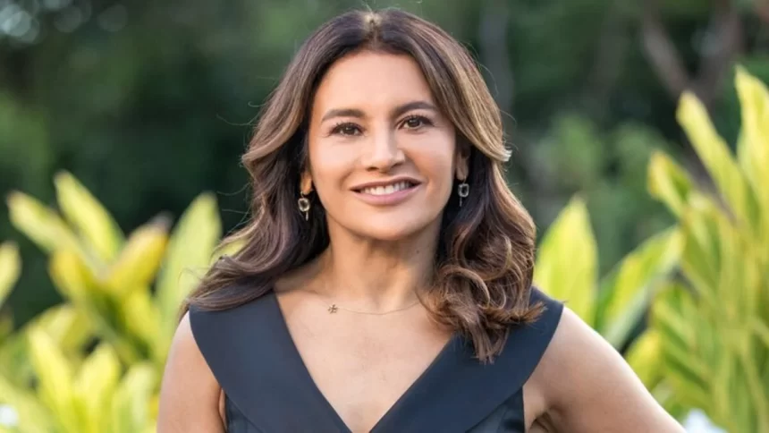 Dira Paes com camisa decotada preta, cabelo solto em corte camada, sorrindo, durante gravação de novela