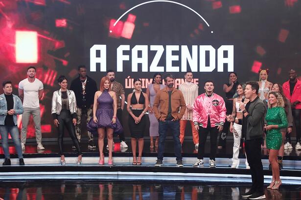 Elenco de A Fazenda 14 no palco do 'Hora do Faro' posicionados num degrau; Rodrigo Faro e Bárbara Borges posicionados na frente deles durante gravação de um quadro especial