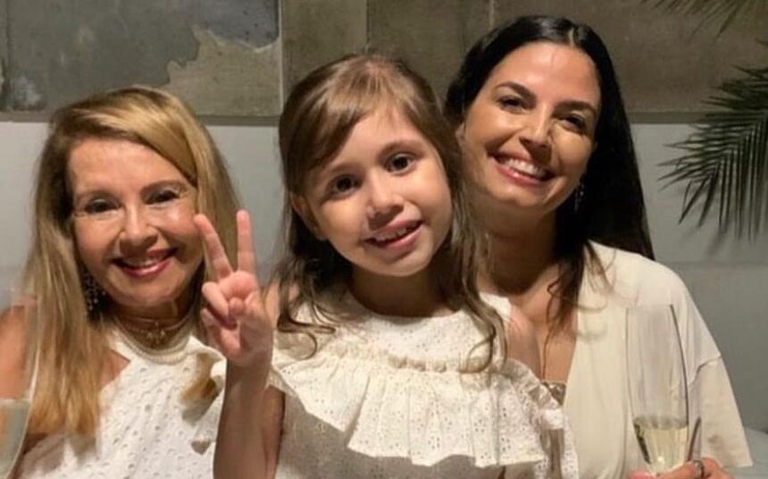 Emanuelle Araujo, sofia e avó de camisa branca, sorrindo, durante reveillon