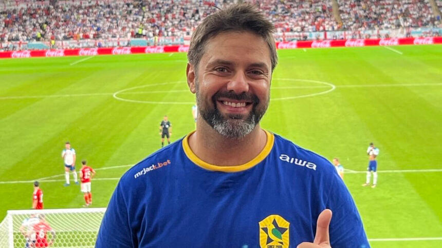 Fábio Rabin em foto posada em um jogo do Brasil na Copa, com o estádio do fundo