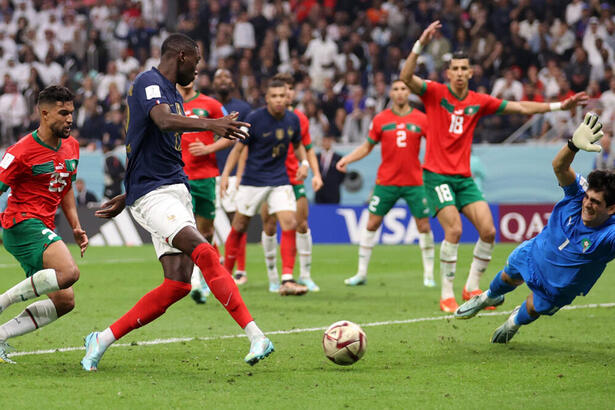 Trecho do jogo entre França e Marrocos, pela semifinal da Copa do Mundo 2022. Ataque da França e o goleiro de Marrocos pulando para defender a bola