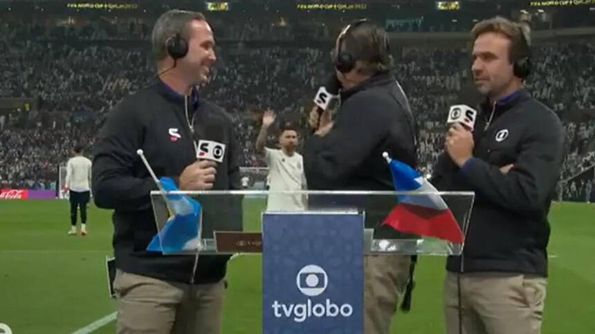 Galvão Bueno, ao lado de Caio Ribeiro e Roger Flores, na beira do gramado, tentando se comunicar com Messi ao fundo, em trecho de transmissão da TV Globo