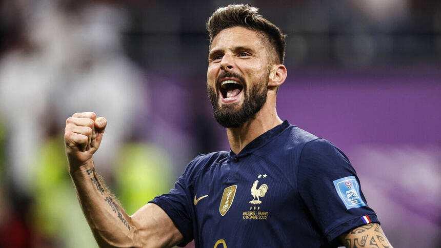 Jogador Giroud, com a camisa da França, comemorando um gol com a camisa da França na Copa do Mundo