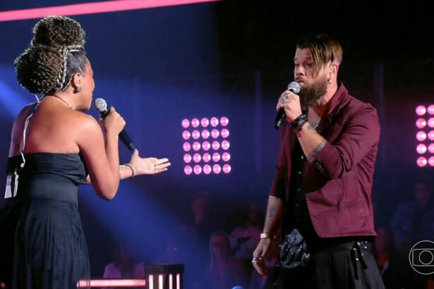 Júlio Mallaguthi e Val Andrade em trecho da batalha no palco do The Voice Brasil 11