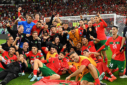 Jogadores e comissão técnica do Marrocos em foto posada juntos no gramado da Copa, após a vitória contra Portugal