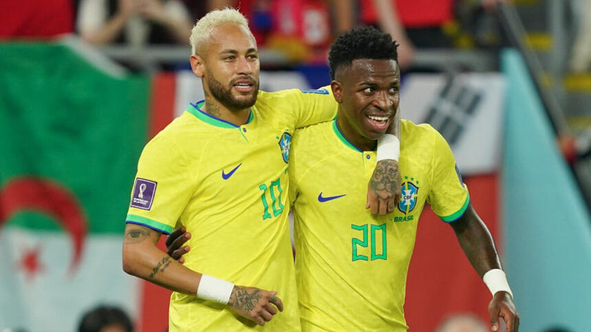 Neymar e Vinícius Jr abraçados, comemorando um gol com a camisa da Seleção na Copa