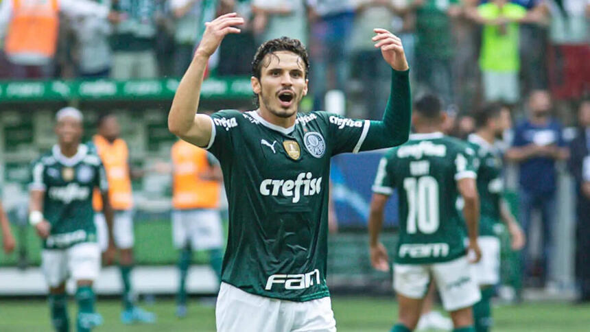 Raphael Veiga, com os braços abertos e levantados, comemorando um gol com a camisa do Palmeiras, na final do Paulistão 2022