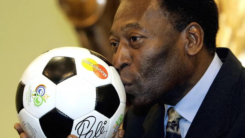 Pelé, de terno, beijando uma bola