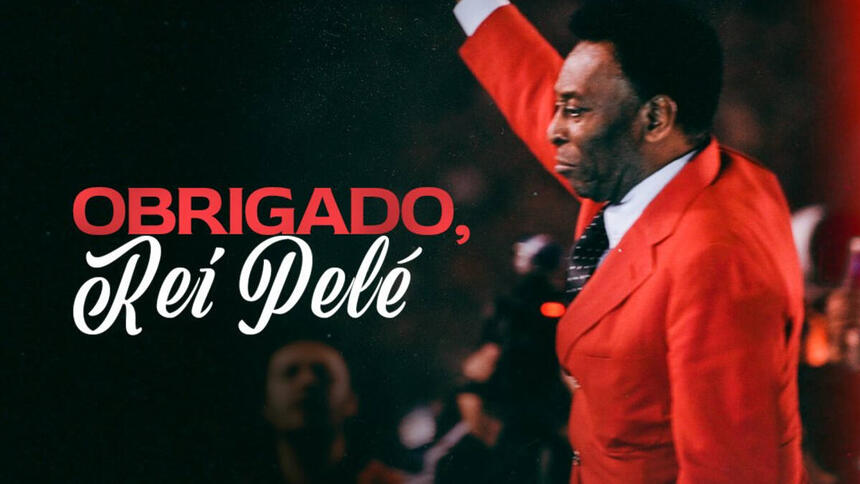 Pelé, com um terno vermelho e braço levantando, saudando o público, além dos escritos "Obrigado, Pelé"