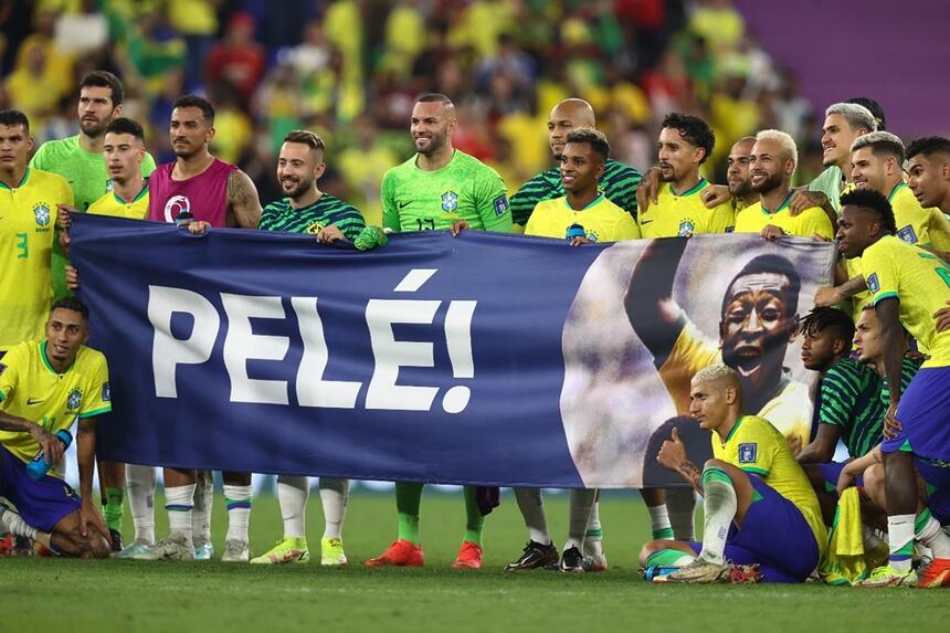 Jogadores da Seleção Brasileira segurando uma faixa com foto e nome de Pelé em sua homenagem