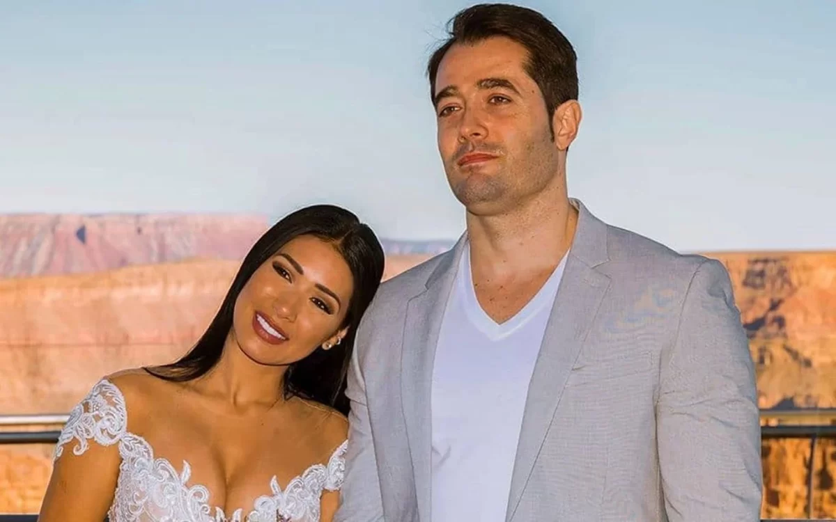 Simaria de vestido de noiva branco, sorrindo, com a cabeça no ombro de Vicente Escrig, que está de blazer prata e camisa social branca