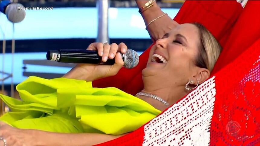 Ticiane Pinheiro sorrindo enquanto leva choques na rede que César Filho ganhou de presente no Família Record