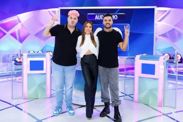 Alvaro e Lucas de camisa preta, calça jeans sorrindo e abraçados com Patricia Abravanel durante gravação do Programa Silvio Santos, do SBT