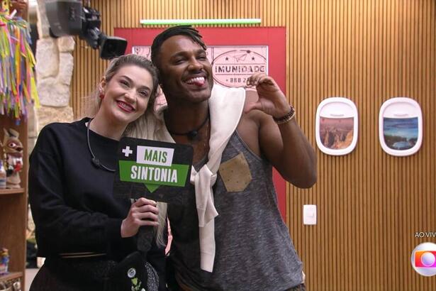 Participantes do BBB 23, Fred Nicácio e Marília seguram placa com os dizeres 'mais sintonia'