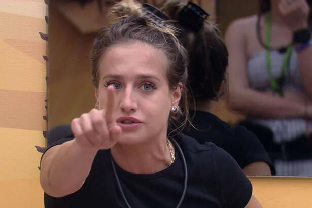 Bruna Griphao, irritada e com dedo em riste, no quarto deserto