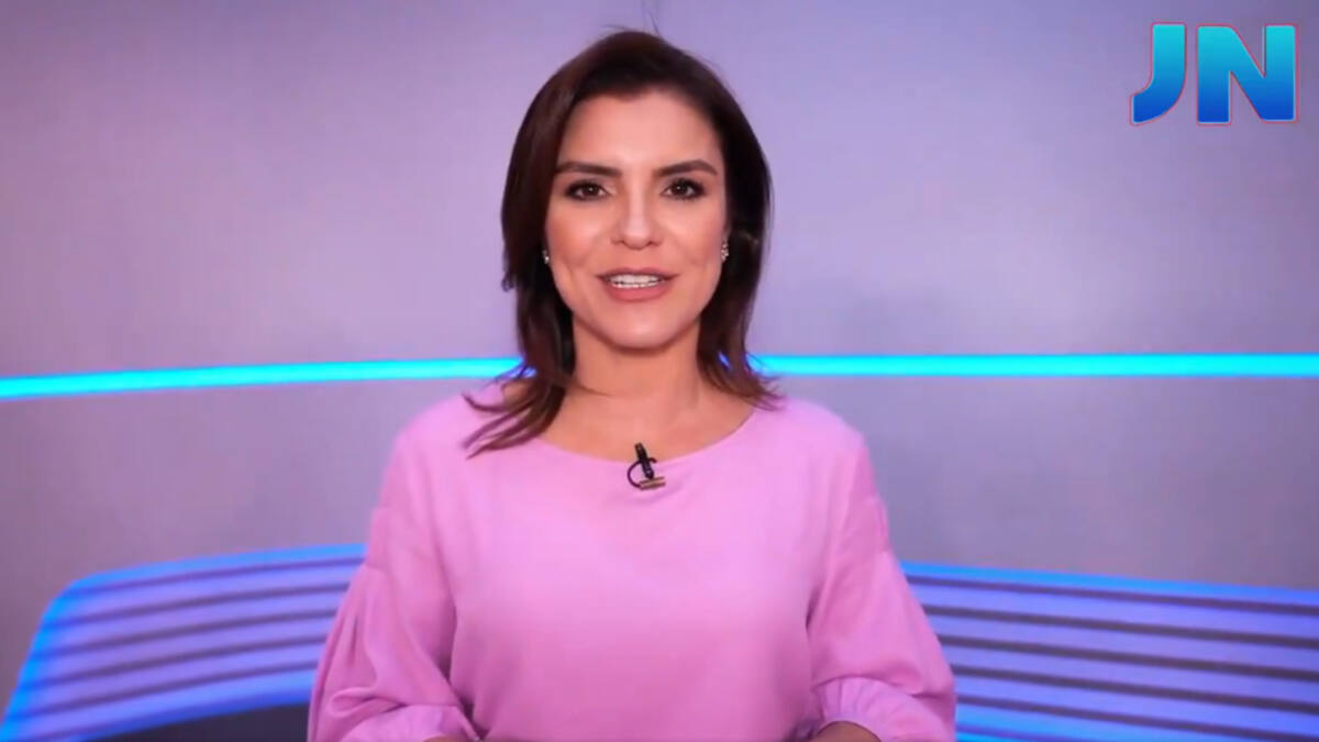 Eliana Marques em frente ao estúdio branco, com leds na cor azul na parte inferior