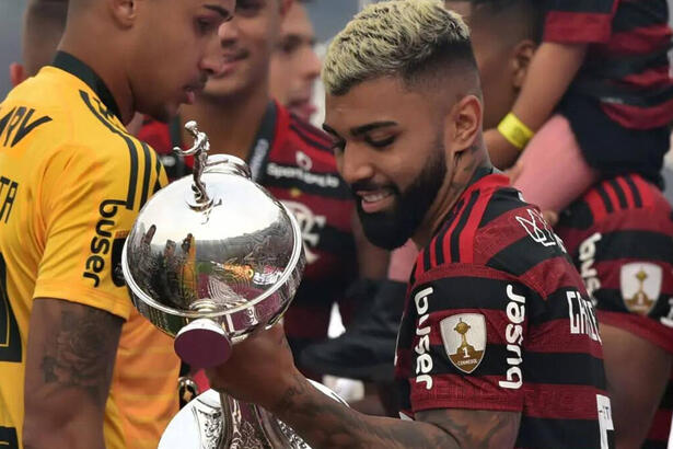 Gabigol com a camisa do Flamengo e segurando a taça da Libertadores