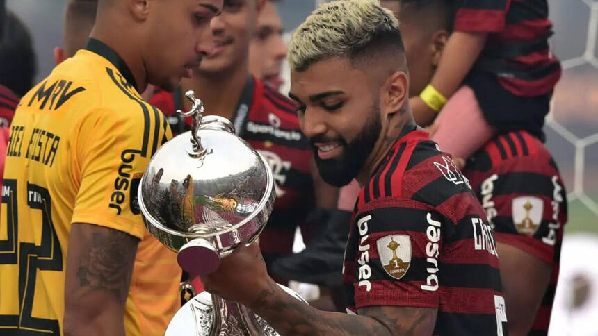 Gabigol com a camisa do Flamengo e segurando a taça da Libertadores