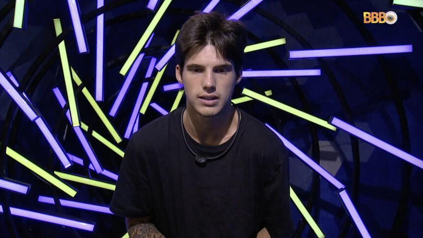 Gabriel Tavares, com uma camiseta preta, no confessionário do BBB 23, em trecho do Raio-X