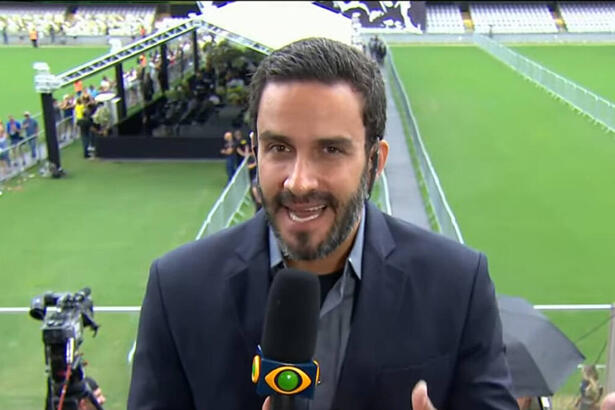 João Paulo Vergueiro, de terno, na Vila Belmiro, com visão do gramado ao fundo, tendo tendas montadas, durante o velório do Pelé