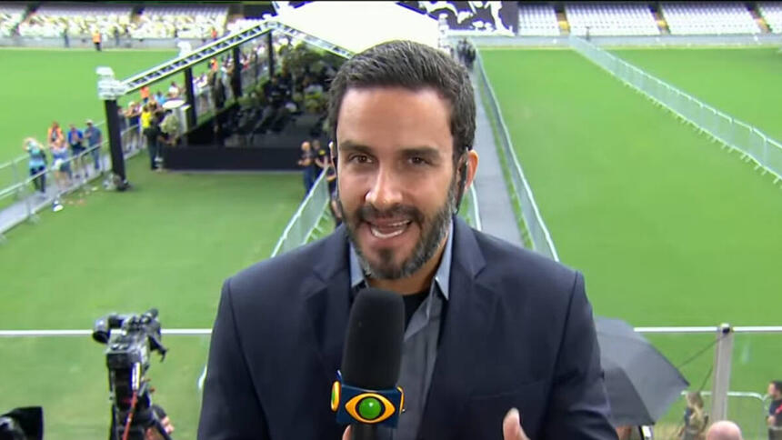 João Paulo Vergueiro, de terno, na Vila Belmiro, com visão do gramado ao fundo, tendo tendas montadas, durante o velório do Pelé