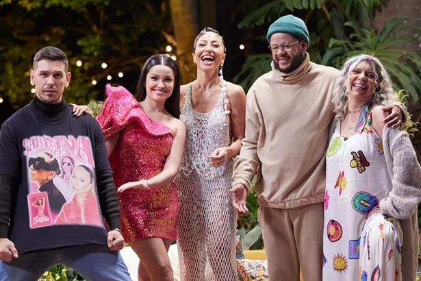 João Vicente de camisa preta e calça jeans, sorrindo, segurando a camisa; Juliette sorrindo, de vestido rosa; Sabrina Santo de vestido decotado branco, sorrindo; Emicida de toca verde com camisa e calça bege, sorrindo; Aristides Fontenelle de look branco com estampa em amarelo e vermelho durante gravação do Saia Justa