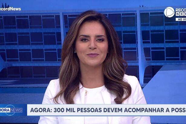 Kelly Godoy de blusa branca no cenário especial da Record News montado para a cobertura da Posse de Lula