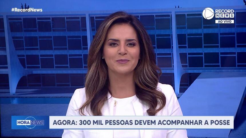 Kelly Godoy de blusa branca no cenário especial da Record News montado para a cobertura da Posse de Lula