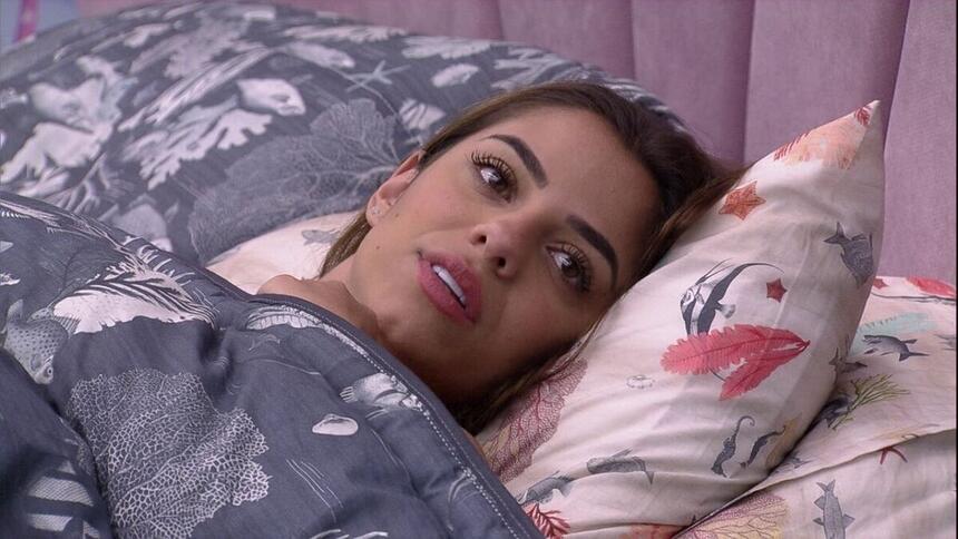 Key Alves deitada na cama, enrolada com edredon, conversando com brothers no quarto do BBB 23