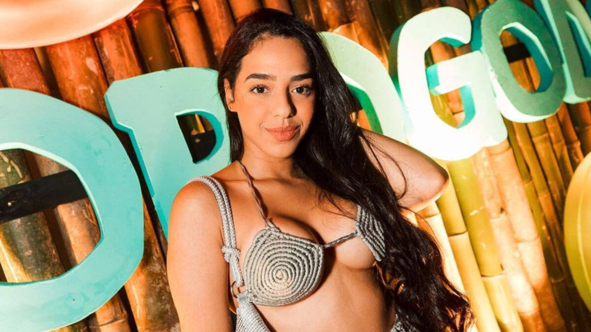Mirella Santos em foto posada, utilizando apenas um biquini e com a mão no cabelo, sorrindo